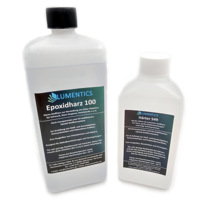 Epoxy resin set with resin and hardener bottles, between them a cast resin piece with a blue-green glowing vein
