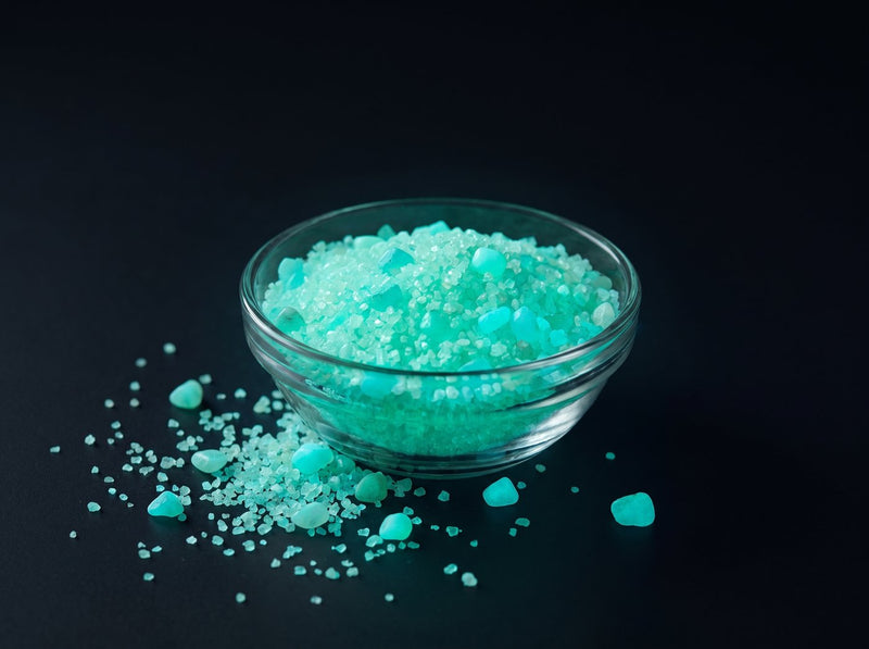 Glow Granules Green 1 mm, 100 g in a glass dish, glowing green in the dark