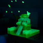 Building brick model on a green baseplate glowing in the dark, glowing stars and rocket behind it