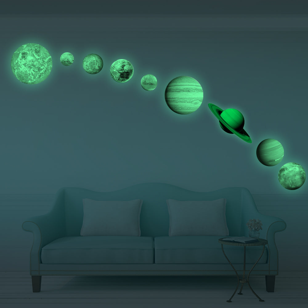 Planet Stickers Solar System glowing green in the dark, on a wall above a sofa