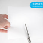 Glow Paper for Laser Printers, 2 x A4: hand holding a white sheet that is being cut with scissors