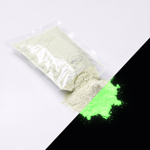 Fine glow pigment Natural Green 100 g: cut-open bag and a small heap of fine powder, whitish by day, glowing green in the dark (lower right)