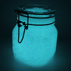 Glow jelly with glitter in a clip-top jar, glowing blue-green in the dark