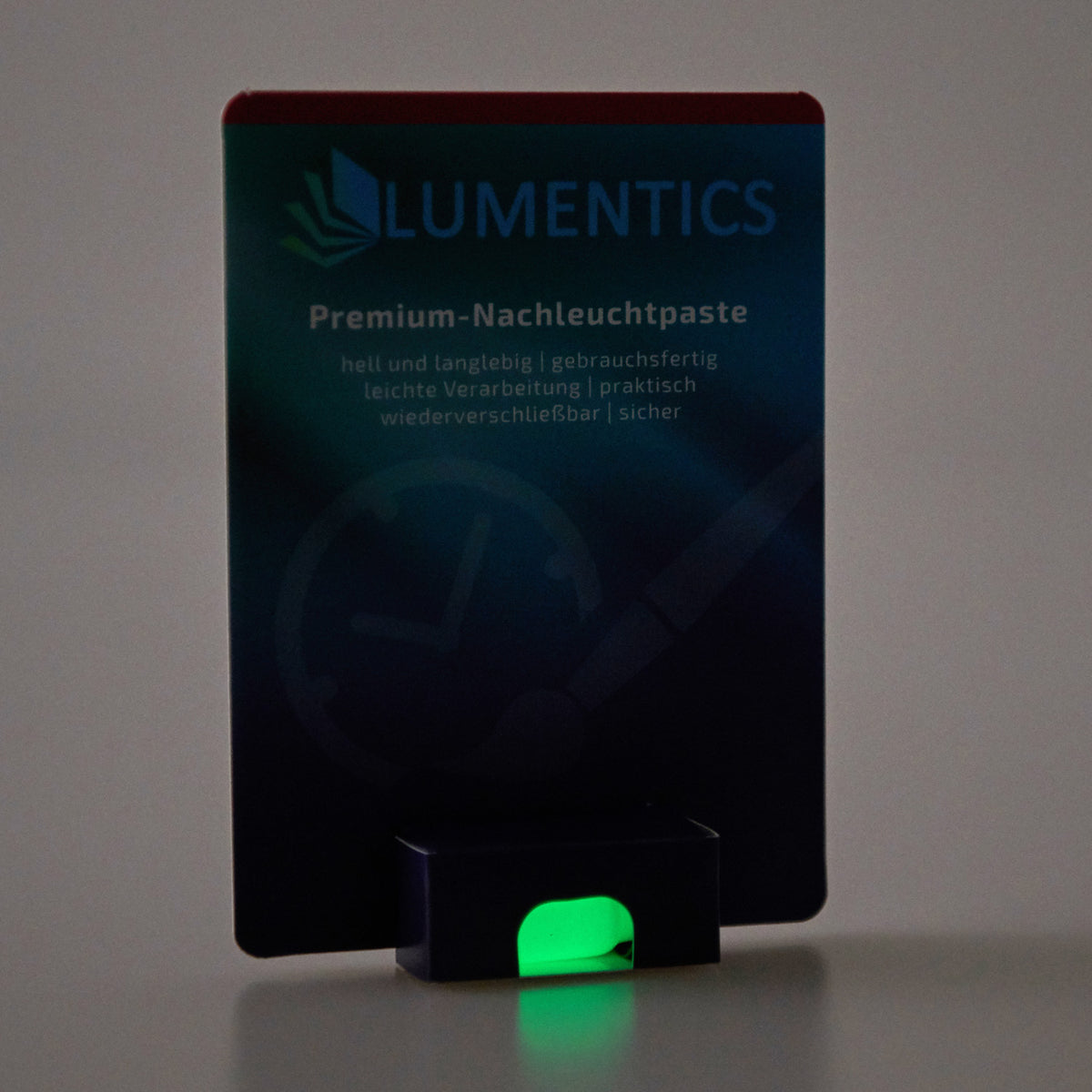 Luminous Paint for Watch Hands Yellow-Green 2 g: card in dim light, the paste in the tub glowing green