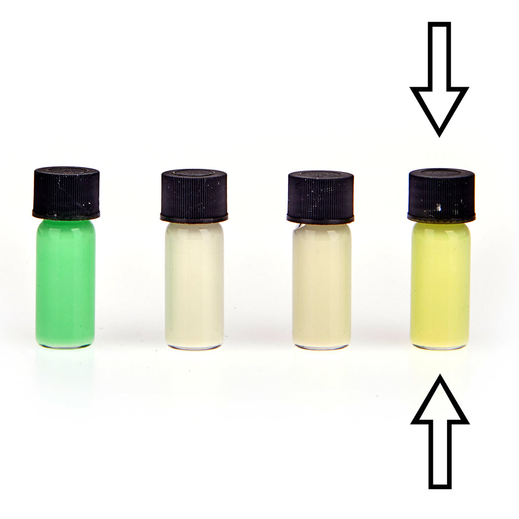 Glow paste colour variants: four vials in daylight, arrows marking the yellow one