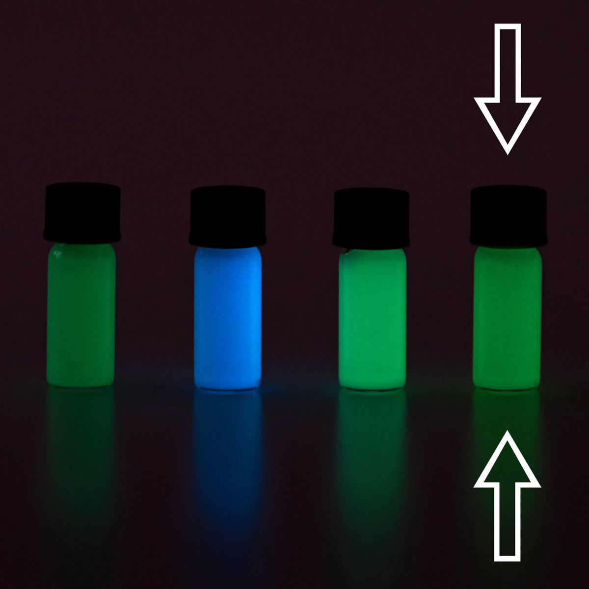 Glow paste colour variants: four vials in the dark, arrows marking the one glowing green