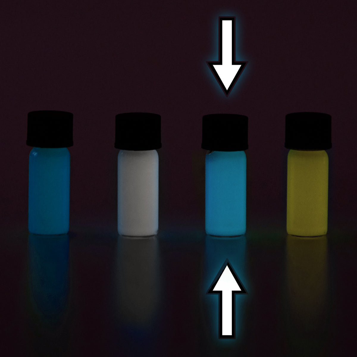 Four small vials with colour samples in the dark, glowing blue, white and yellow, arrows marking one vial