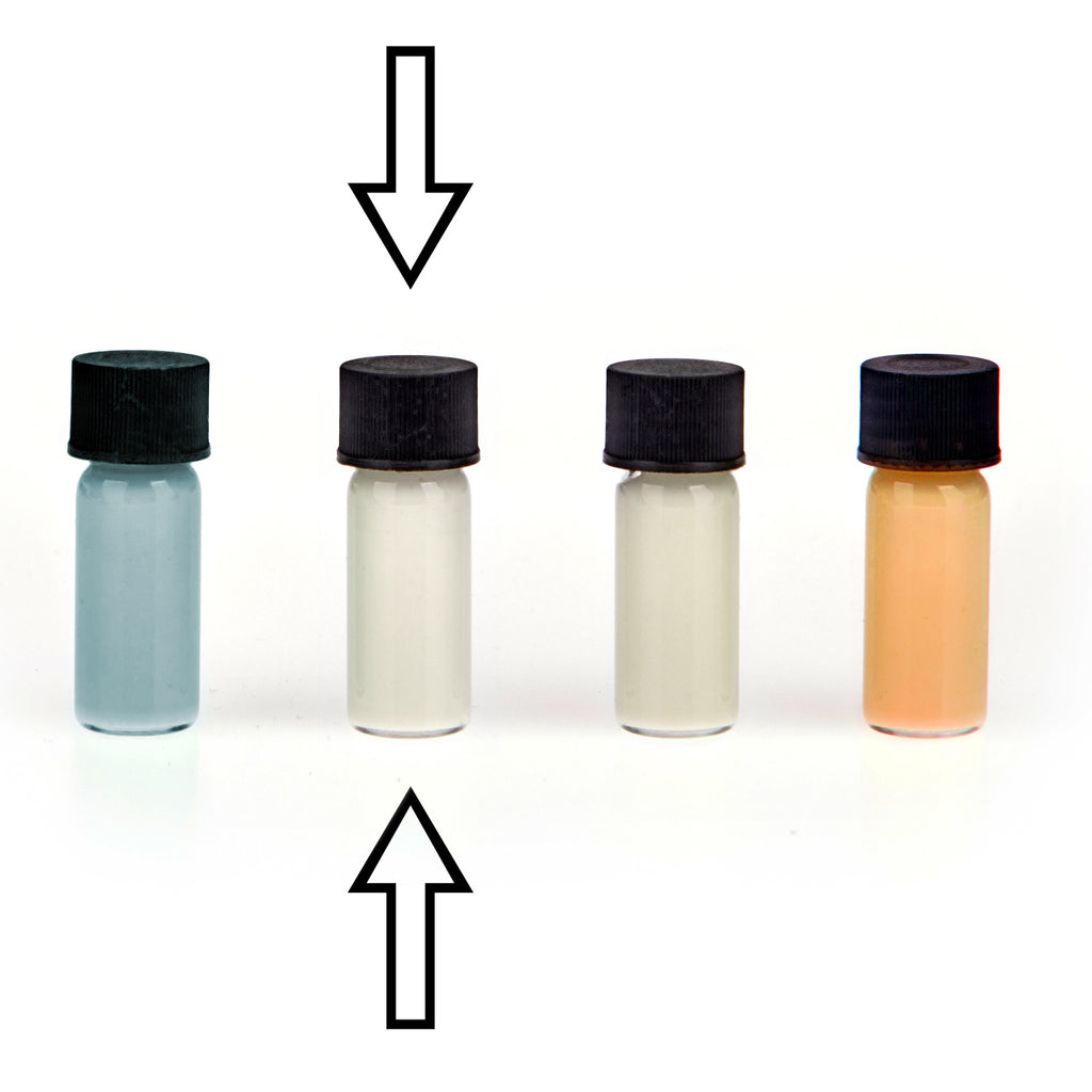 Glow paste colour variants: four vials in daylight, arrows marking the second, a cream-white one