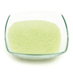 Glow granules 1 mm in a glass dish in daylight, pale green fine-grained granules