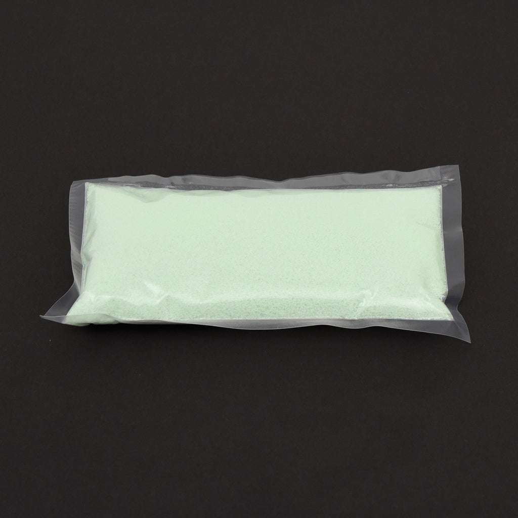 Glow granules 1 mm in a clear bag in daylight, pale green, on a dark background