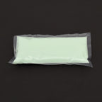 Glow granules 1 mm in a clear bag in daylight, pale green, on a dark background