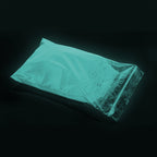 Powder Coating Blue-Green 1 kg in a zip bag, glowing blue-green in the dark