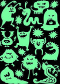 Sheet of Monster glow in the dark stickers in the dark, many green glowing monster shapes and stars on black