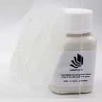 Glitter Glow Paint Blue-Green 100 g: labelled bottle and a glitter paint stroke on acrylic glass in daylight