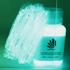 Glitter Glow Paint Blue-Green 100 g: labelled bottle and paint stroke on acrylic glass in the dark, glowing blue-green