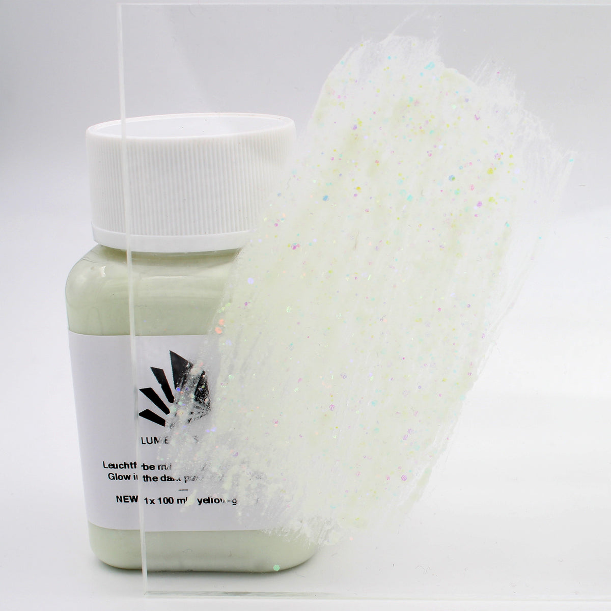 Glitter Glow Paint Yellow-Green 100 g: bottle with a paint stroke on an acrylic sheet in daylight, glitter visible