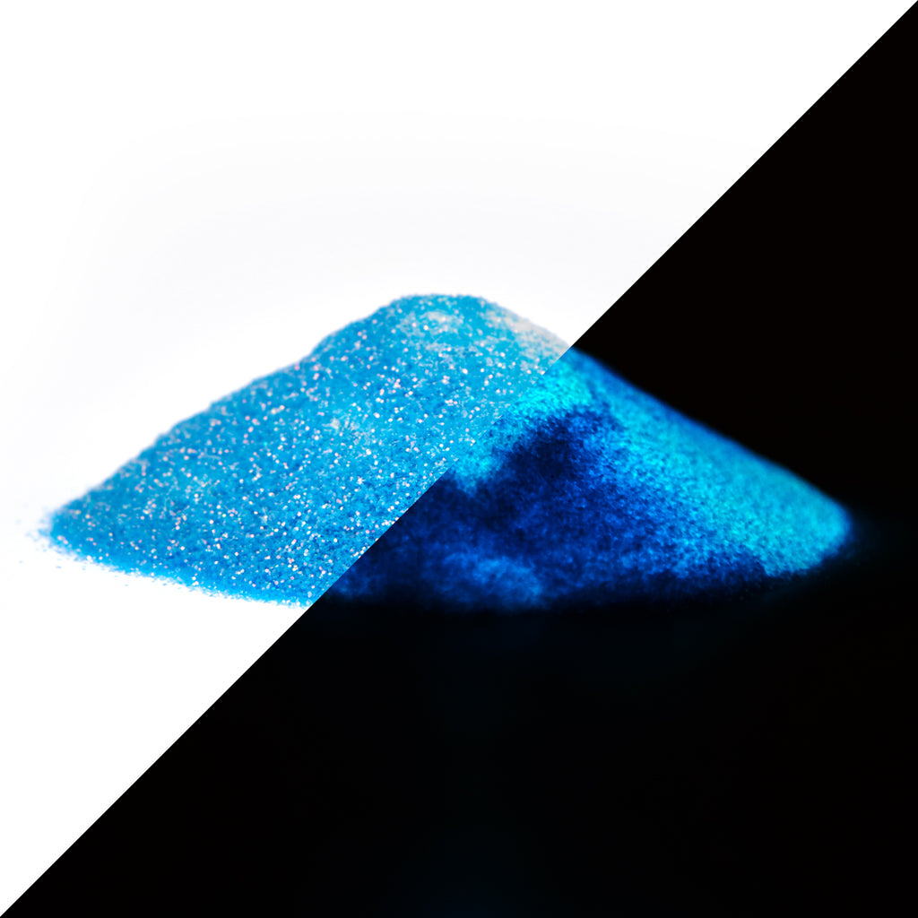 Glitter powder Blue 50 g as a pile, split diagonally: daylight on the left, glowing blue in the dark on the right