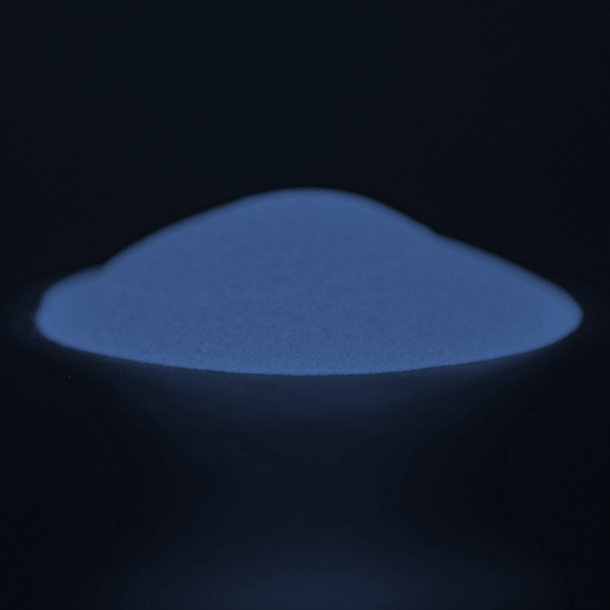 Glow in the Dark Powder Blue-Blue 40 g: heap of powder in the dark, glowing blue