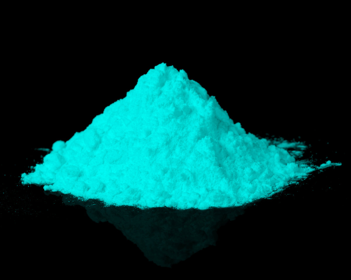 Glow in the Dark Powder Blue-Green 40 g: pile of powder in the dark, glowing turquoise-blue on black