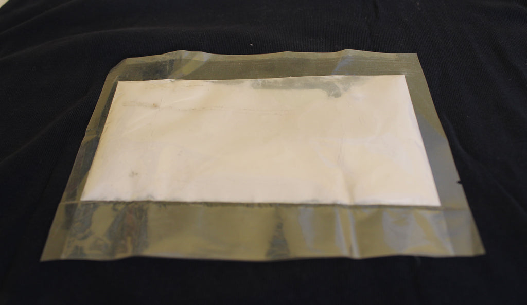 Glow in the Dark Powder Purple 40 g in a flat bag in daylight, pale whitish powder