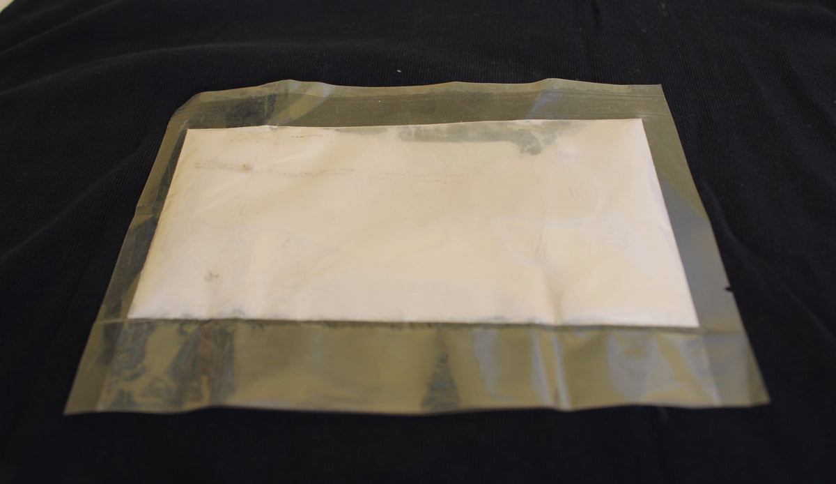 Glow in the Dark Powder Purple 40 g in a flat bag in daylight, pale whitish powder
