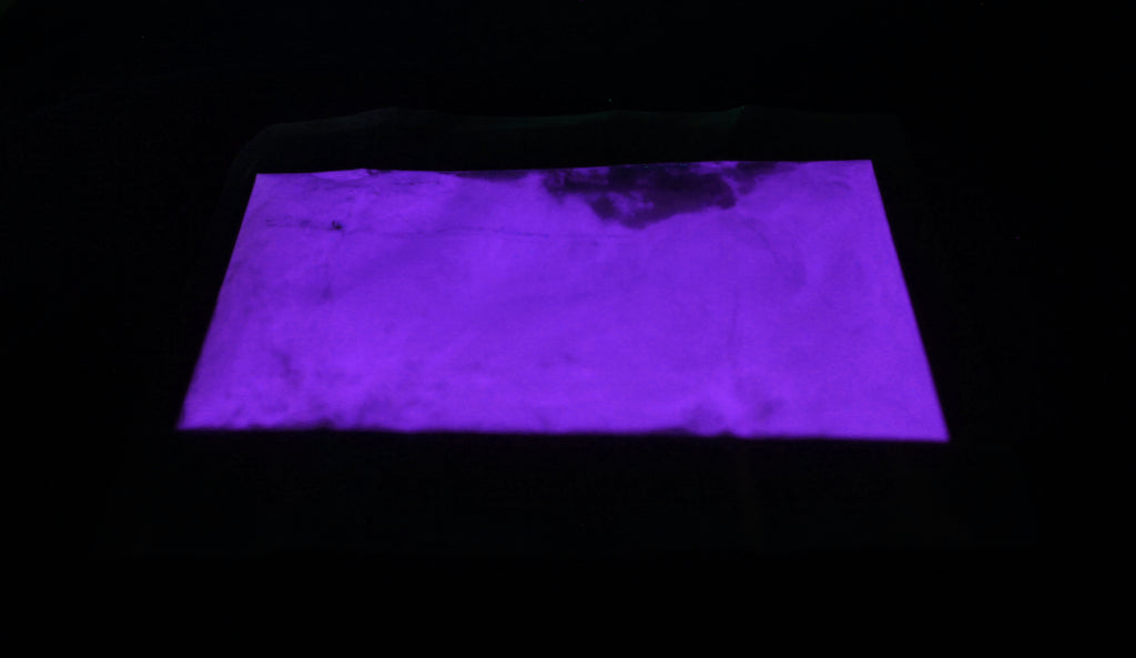 Glow in the Dark Powder Purple 40 g in a flat bag in the dark, glowing violet