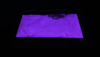 Glow in the Dark Powder Purple 40 g in a flat bag in the dark, glowing violet