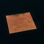 Glow in the Dark Powder Red 40 g: coated sample surface in the dark with an orange afterglow