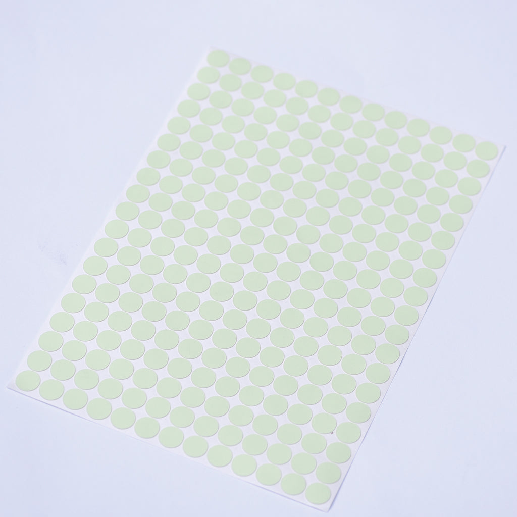 Glow dots 1.5 cm, sticker sheet seen from above at an angle with the dots arranged in rows