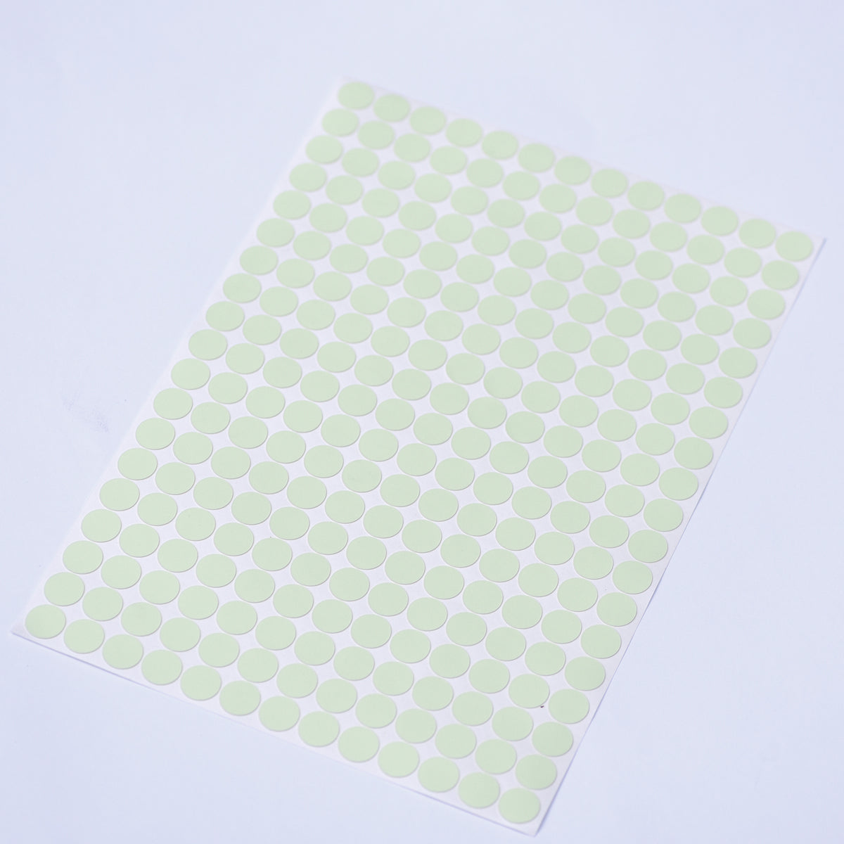 Glow dots 1.5 cm, sticker sheet seen from above at an angle with the dots arranged in rows