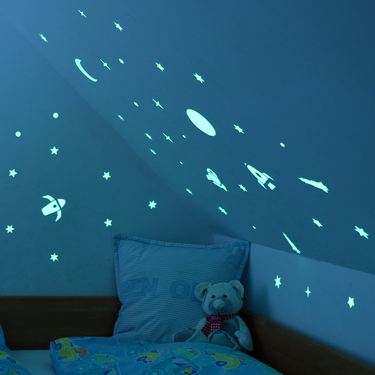 Glow in the Dark Stickers Rockets, A4 sheet: sloping ceiling in the dark, stars and rockets glowing bluish above the bed