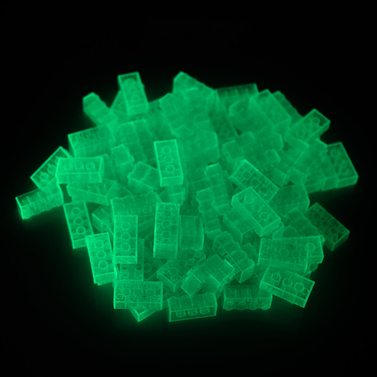 Building bricks 2x4 blue in a pile, glowing green in the dark