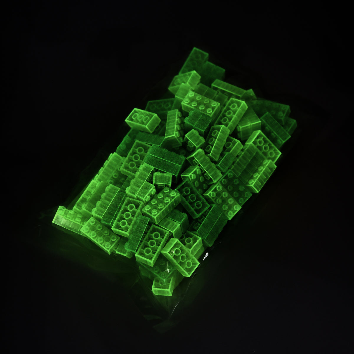 Building Bricks 2x4 Yellow in their bag in the dark, glowing green