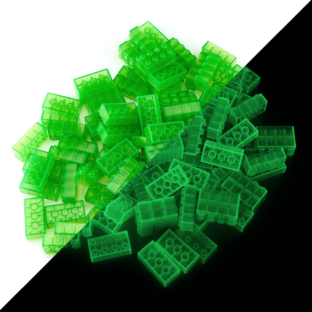 Building bricks 2x4 green, 100 pieces: pile split diagonally, daylight on the left, glowing in the dark on the right