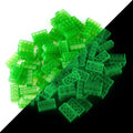 Building bricks 2x4 green, 100 pieces: pile split diagonally, daylight on the left, glowing in the dark on the right