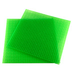 Glow-in-the-dark baseplates green, two overlapping studded plates in daylight