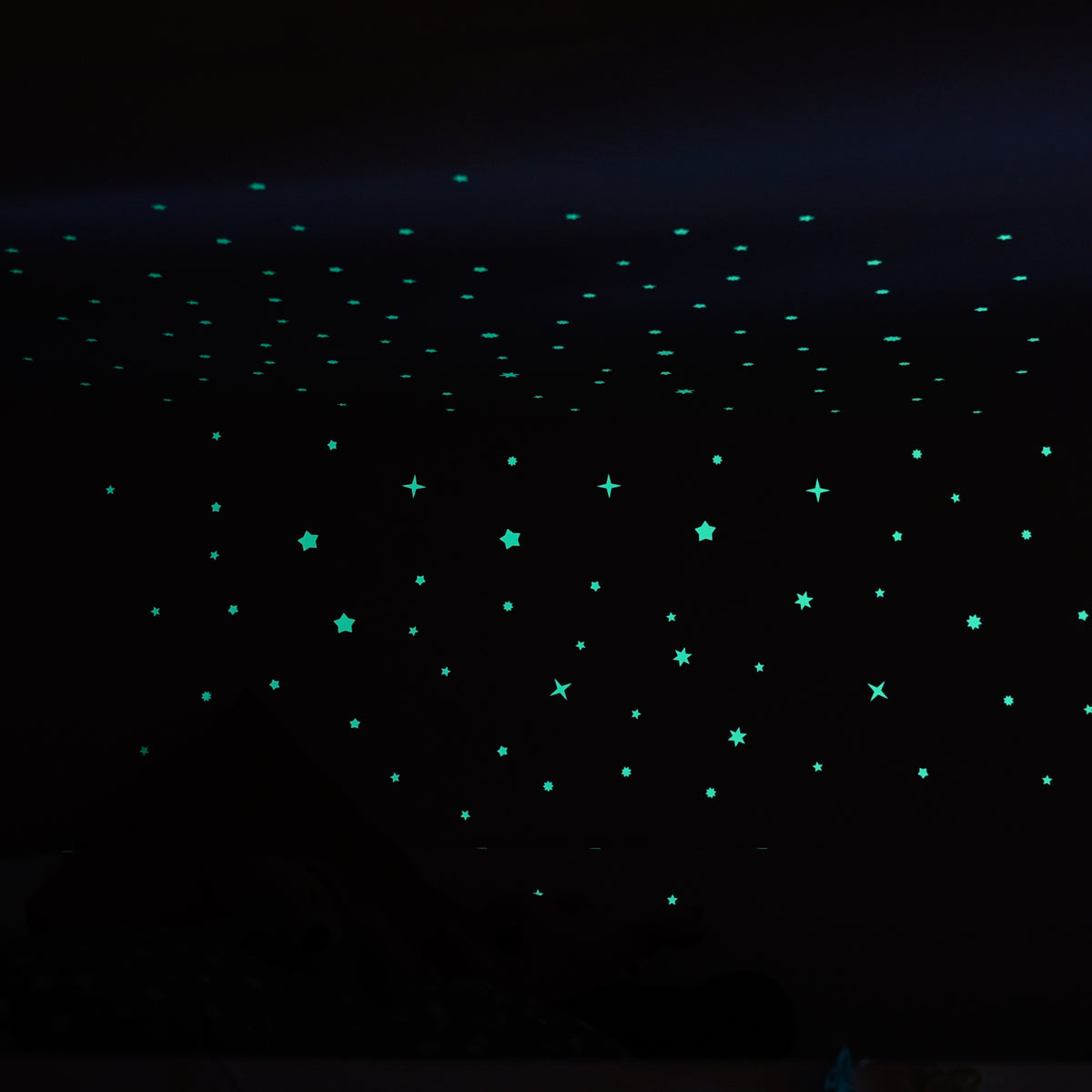 Glow stars on ceiling and wall in a dark room, only the stars glowing greenish