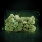 Glow Stones Brown 300 g in a clear bag in the dark, glowing faint green