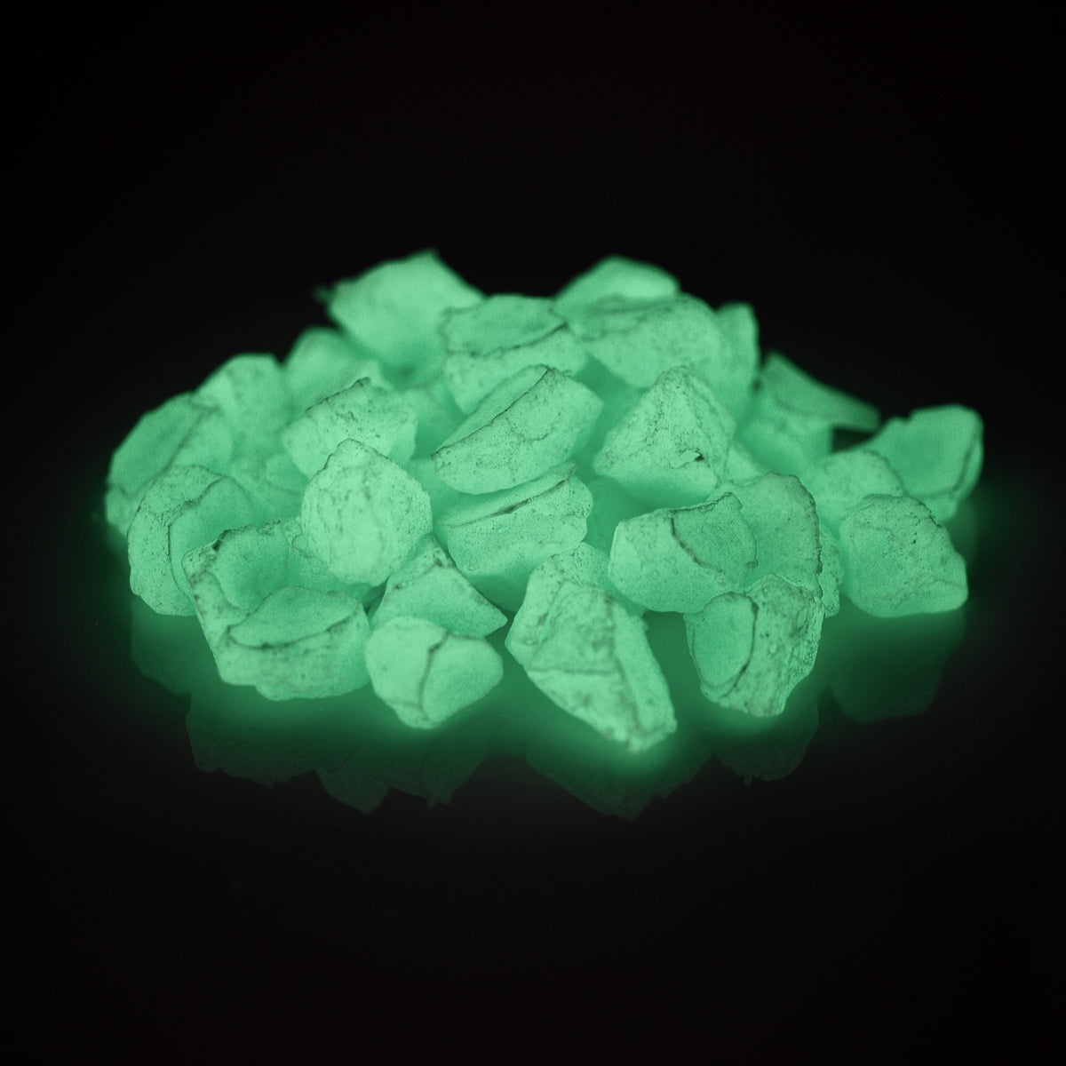 Glow Stones Blue-Green 300 g in the dark, green-blue glowing stones on a black background