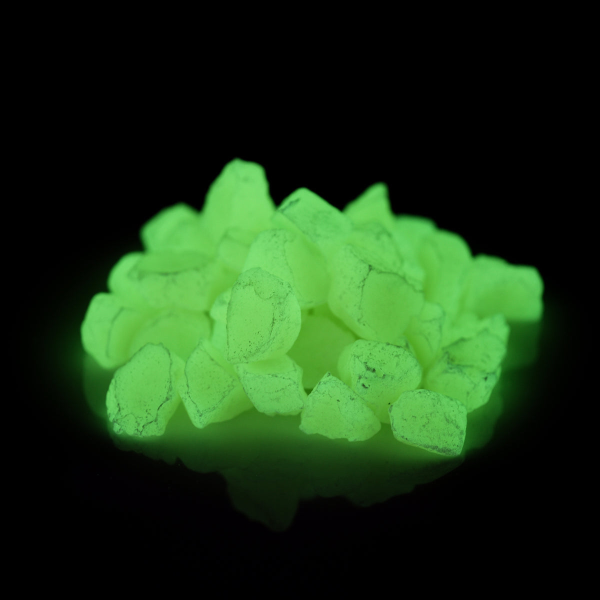 Glow Stones Yellow 300 g in the dark, yellow-green glowing stones on a black background