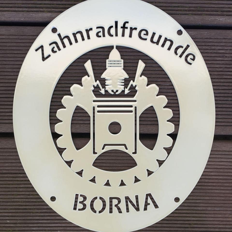 Metal club emblem with powder coating in daylight, pale plaque on a wooden wall